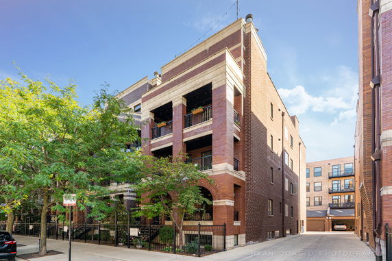 Front view of a multi-story brick building with balconies.