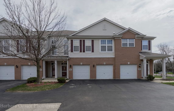Front view of a two-story townhouse with an attached garage.