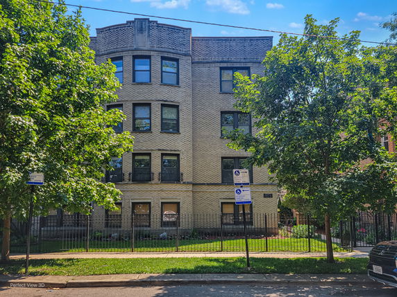 Front view of a three-story apartment building with a brick facade.