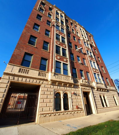 Front view of a multi-story brick building with detailed architecture.