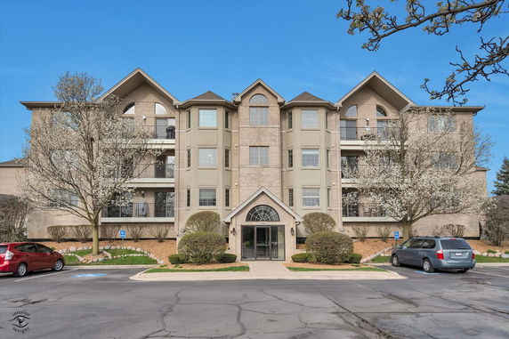 Front view of a multi-story residential building with symmetrical design and bay windows.