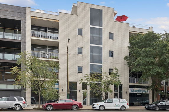 Front view of a multi-story building with large windows and balconies.