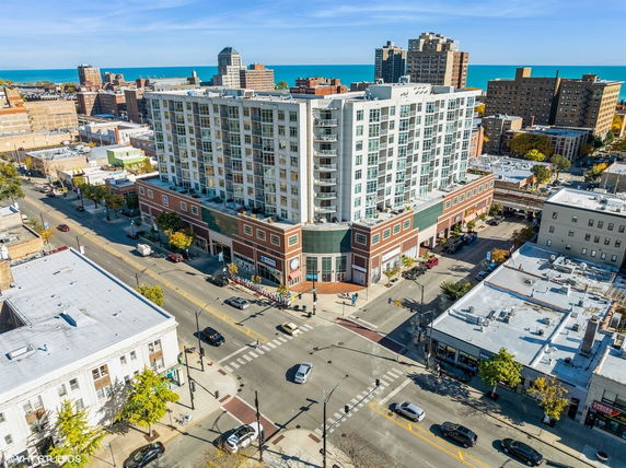 Front view of a large multi-story building with a commercial base and residential upper floors in an urban area.