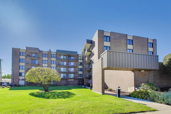 Front view of a multi-story apartment building with balconies.