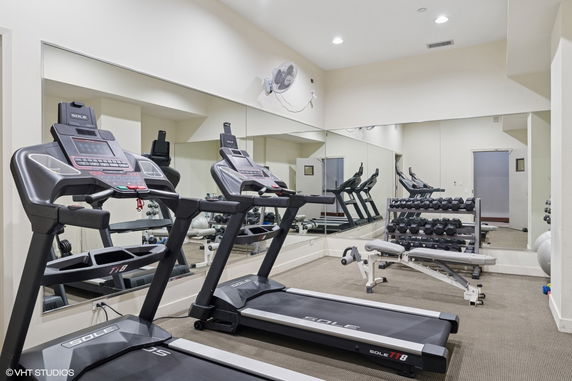 Indoor gym area with treadmills and weights.