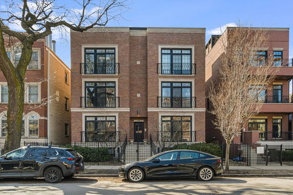 Front view of a three-story brick building with balconies.