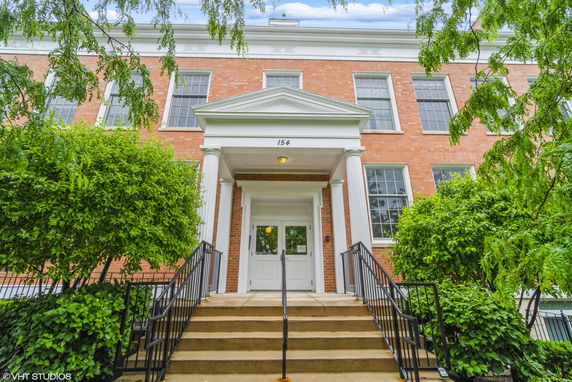 Front view of a two-story brick building with columns and multiple windows.