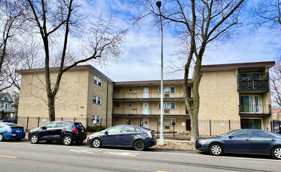 Front view of a three-story apartment building with balconies.