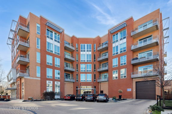 Front view of a multi-story brick apartment building with balconies.