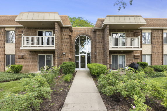 Front view of a two-story brick apartment building with balconies.