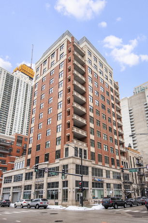 Front view of a multi-story building with brick facade and balconies.