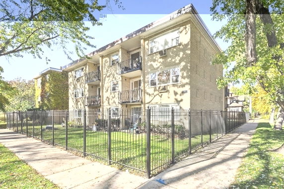 Front view of a three-story apartment building with balconies.