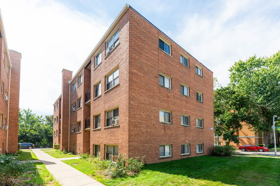 Front view of a four-story brick apartment building.