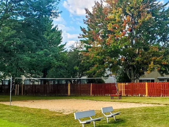 Outdoor volleyball court with sand and benches