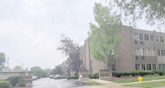 Front view of a multi-story condominium building with a brick facade.