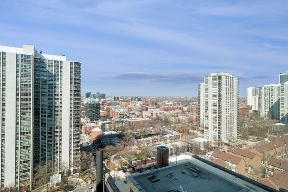 Panoramic view of high-rise buildings and a cityscape under a blue sky.