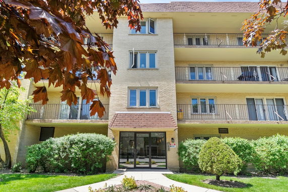 Front view of a multi-story apartment building with balconies.