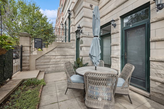 Front view of a multi-story building with a stone facade and outdoor seating area.