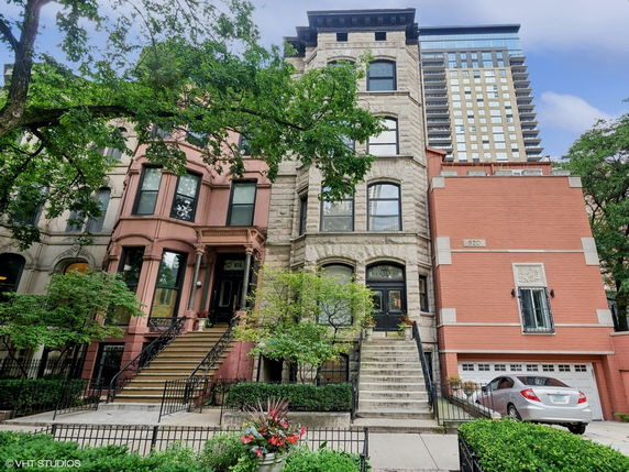 Front view of a row of multi-story townhouses with distinctive architectural styles.