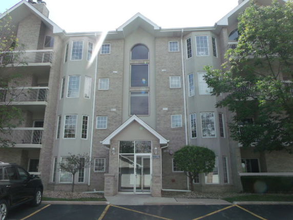 Front view of a multi-story apartment building with balconies.