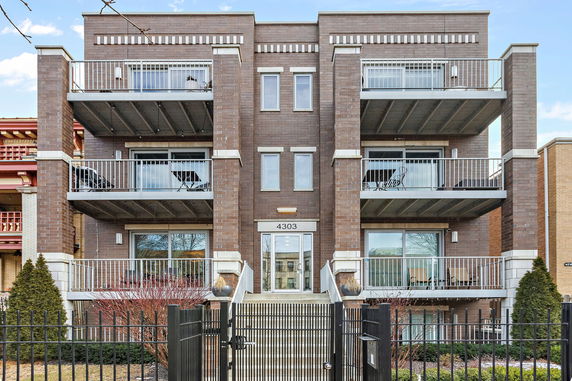 Front view of a multi-story brick building with balconies.