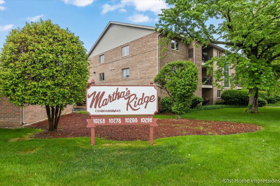 Front view of a multi-story condominium building with a sign reading 'Martha's Ridge Condominiums'.