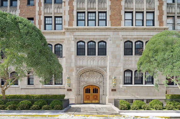 Front view of a multi-story building with ornate architectural details and arched entrance.