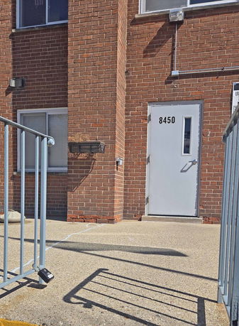 Front view of a brick building with a white door.