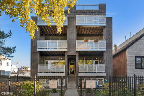 Front view of a multi-story brick building with balconies.