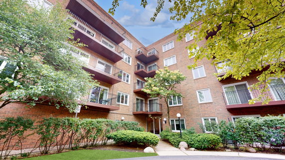 Exterior view of a multi-story brick apartment building with balconies.