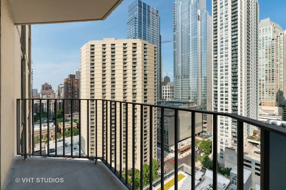 View from a balcony overlooking a cityscape with multiple high-rise buildings.
