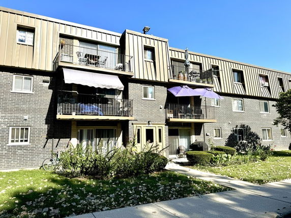 Front view of a multi-story residential building with balconies.