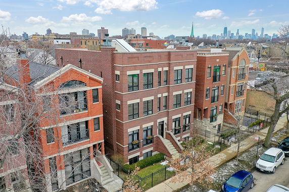 Front view of a row of multi-story brick buildings in an urban area.