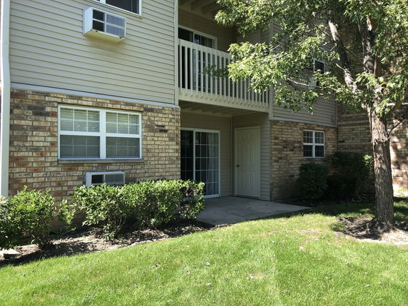 Front view of a multi-story building with brick and siding exterior.