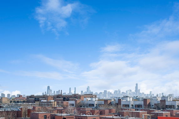Distant view of a city skyline with tall buildings against a blue sky.