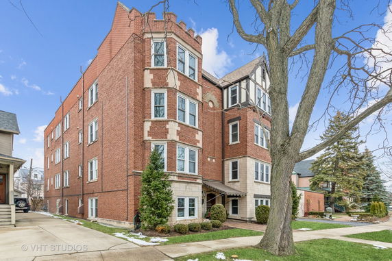 Front view of a multi-story brick building with multiple windows.