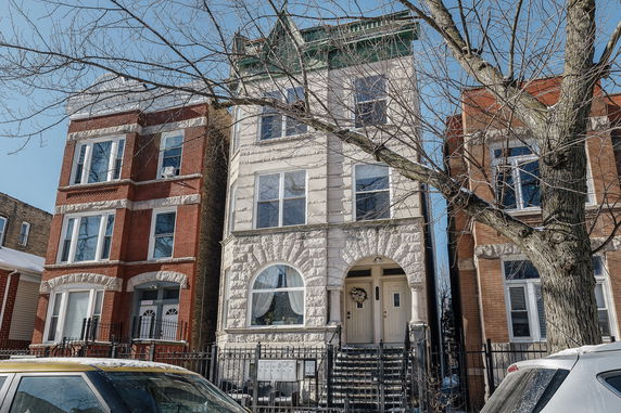 Front view of a multi-story residential building with a decorative brick facade.