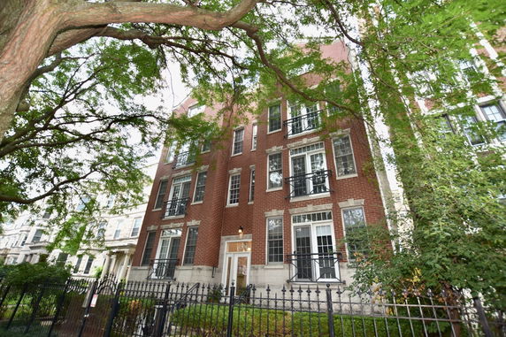 Front view of a multi-story brick building with multiple windows and a central entrance.