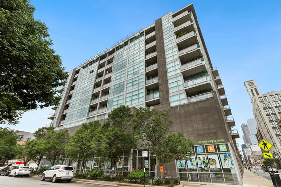 Front view of a multi-story modern building with large windows and balconies.