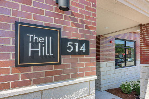 Front view of a brick building with signage displaying 'The Hill 514'.