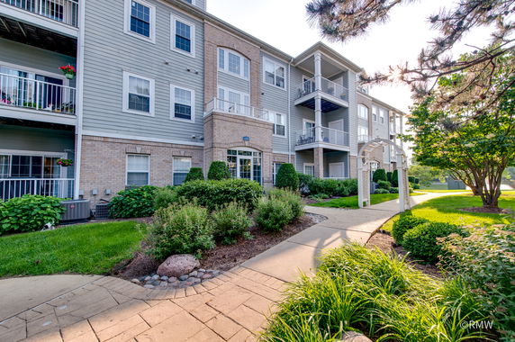 Front view of a multi-story residential building with balconies and landscaping.