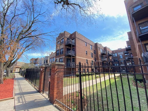 Front view of a multi-story brick apartment building.