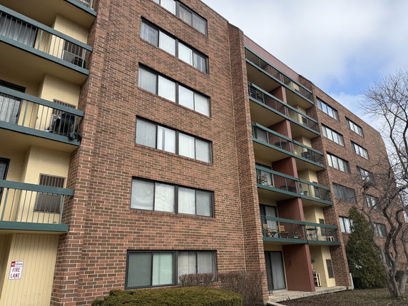 Front view of a multi-story apartment building with balconies.