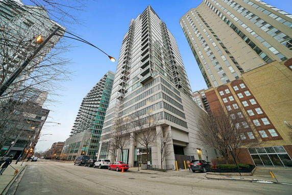 Front view of a tall modern multi-story building on a city street.