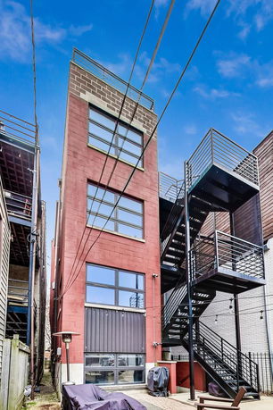 Front view of a multi-story building with brick exterior and external staircase.