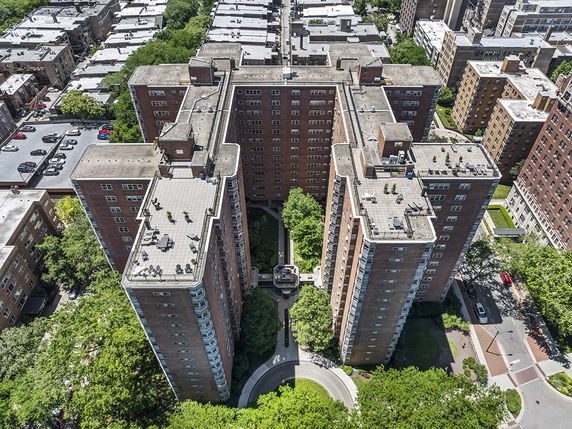 Aerial view of multi-story brick apartment buildings with flat rooftops.