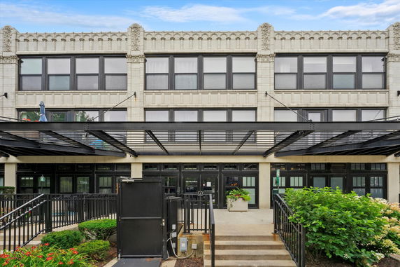 Front view of a multi-story building with large windows and decorative facade.