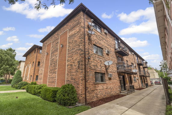Front view of a multi-story brick apartment building.
