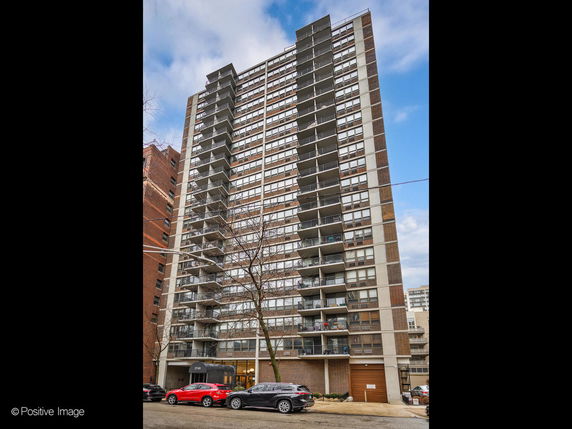 Front view of a high-rise apartment building with multiple balconies.