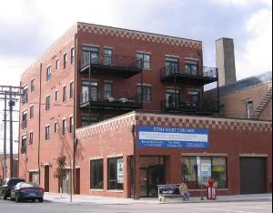 Front view of a multi-story brick building with balconies.